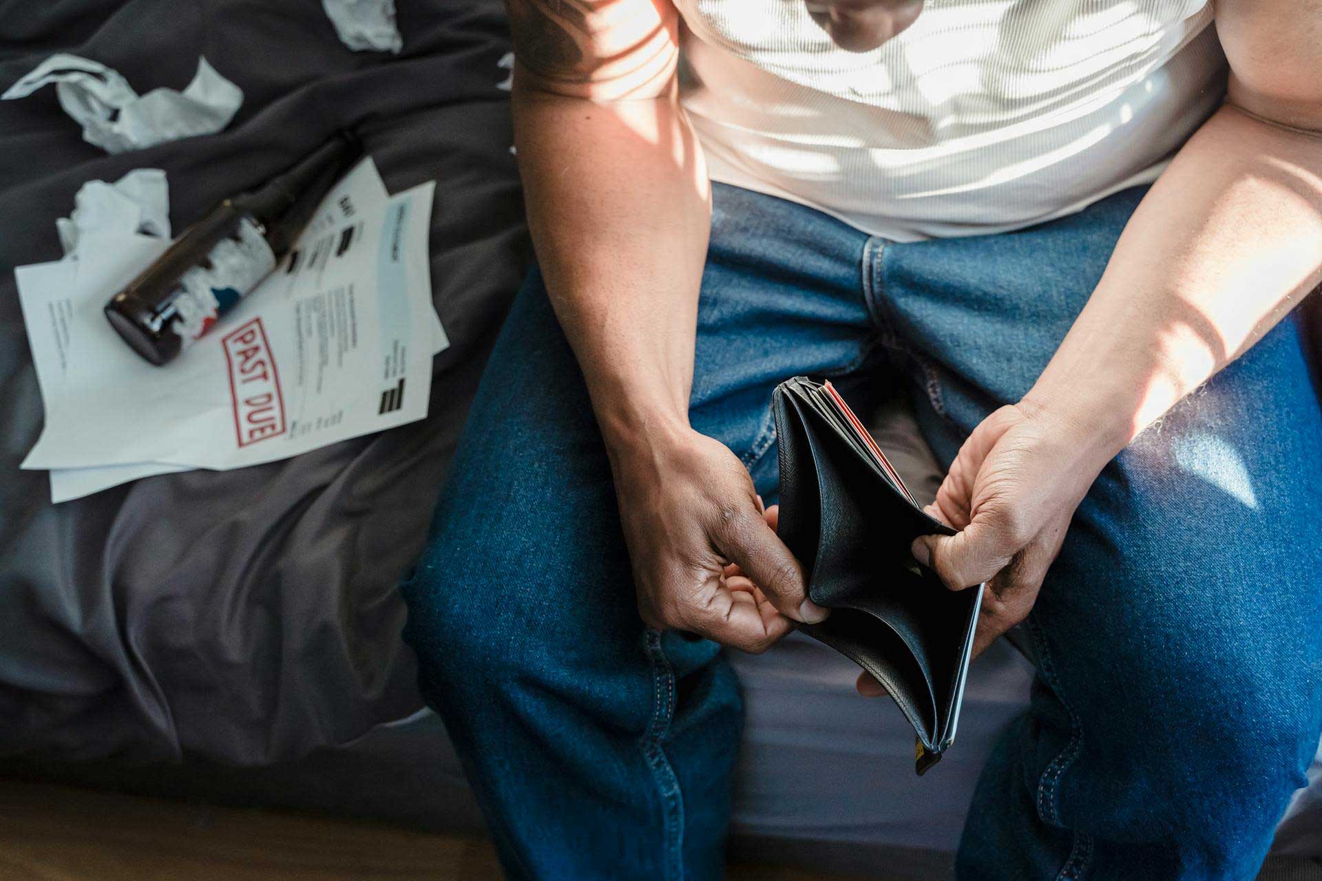 A royalty-free photograph from Pexels depicts a man gazing into an empty wallet.