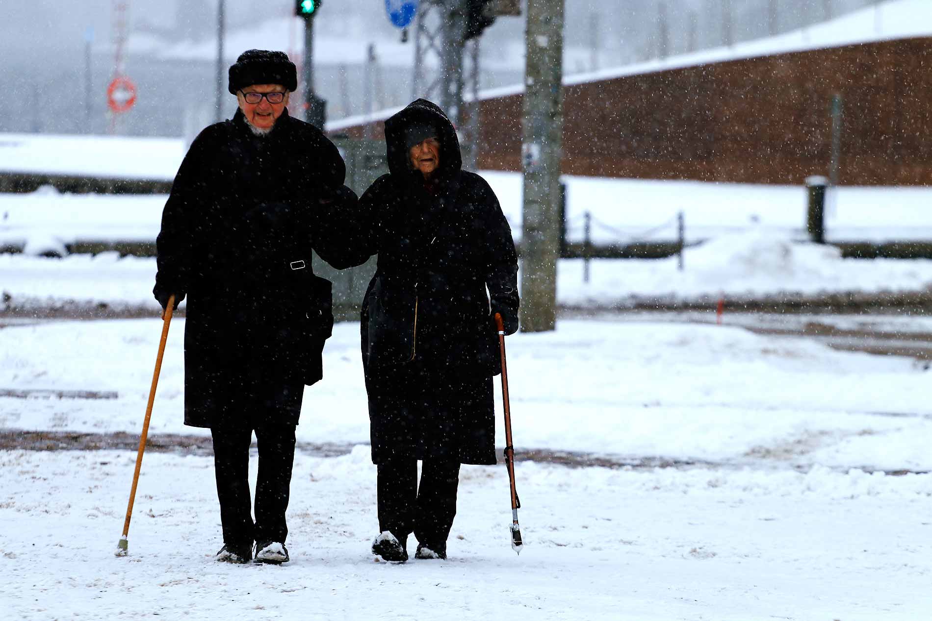 An elderly couple takes a stroll in wintry weather in a photograph by Tony Öhberg for Finland Today.