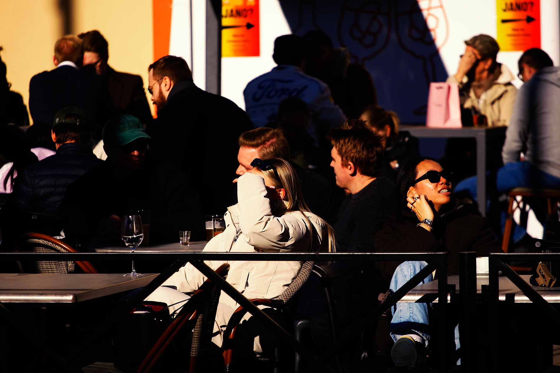 People sitting on a sunny terrace in Kamppi, Helsinki, enjoying a warm April afternoon in a photograph by Tony Öhberg for Finland Today.