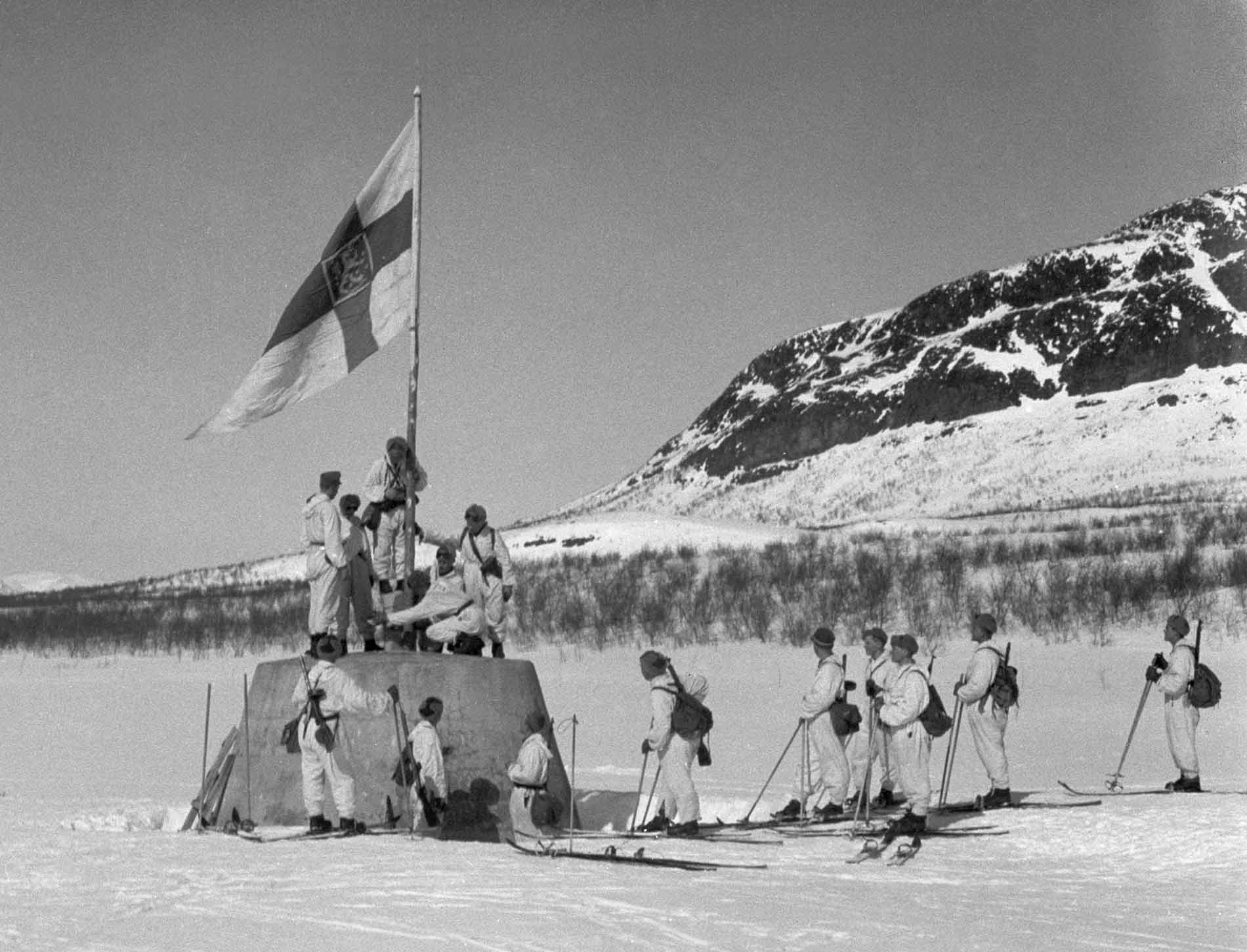 Finnish soldiers hoisting a flag on the cairn in April 1945, marking the conclusion of the Second World War in Finland. Photograph: Vaäino Oinonen/Public Domain